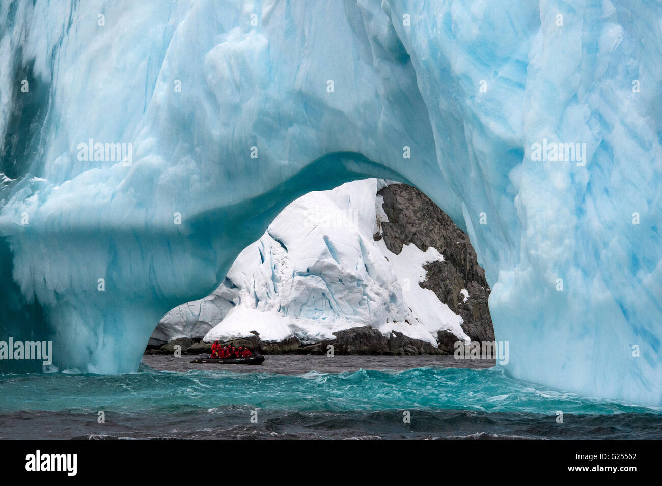 Arco di ghiaccio con tourist zodiac passando da Melchior Islands, Antartide Foto Stock