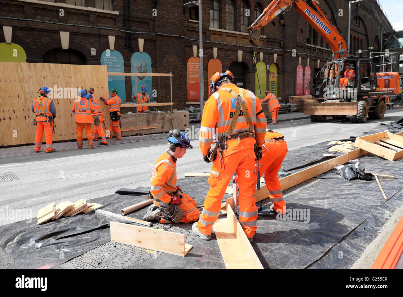 Lavoratori che indossano elmetti che lavorano allo sviluppo di Thameslink e Network Rail in Tooley Street vicino alla stazione London Bridge South London UK KATHY DE Foto Stock