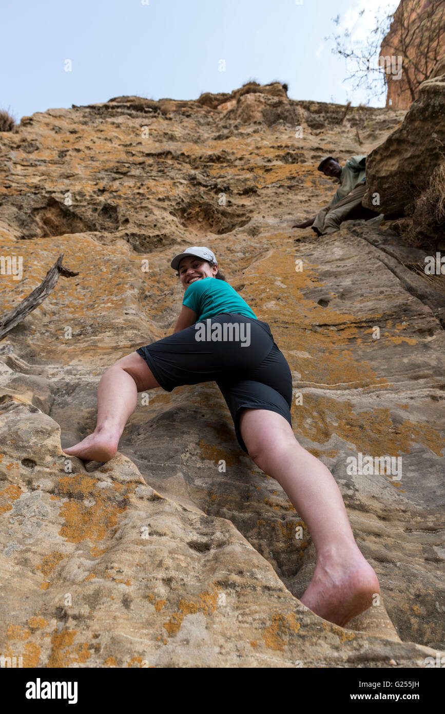 La donna la scalata su roccia per raggiungere la roccia scavate chiesa Gheralta, Etiopia Foto Stock