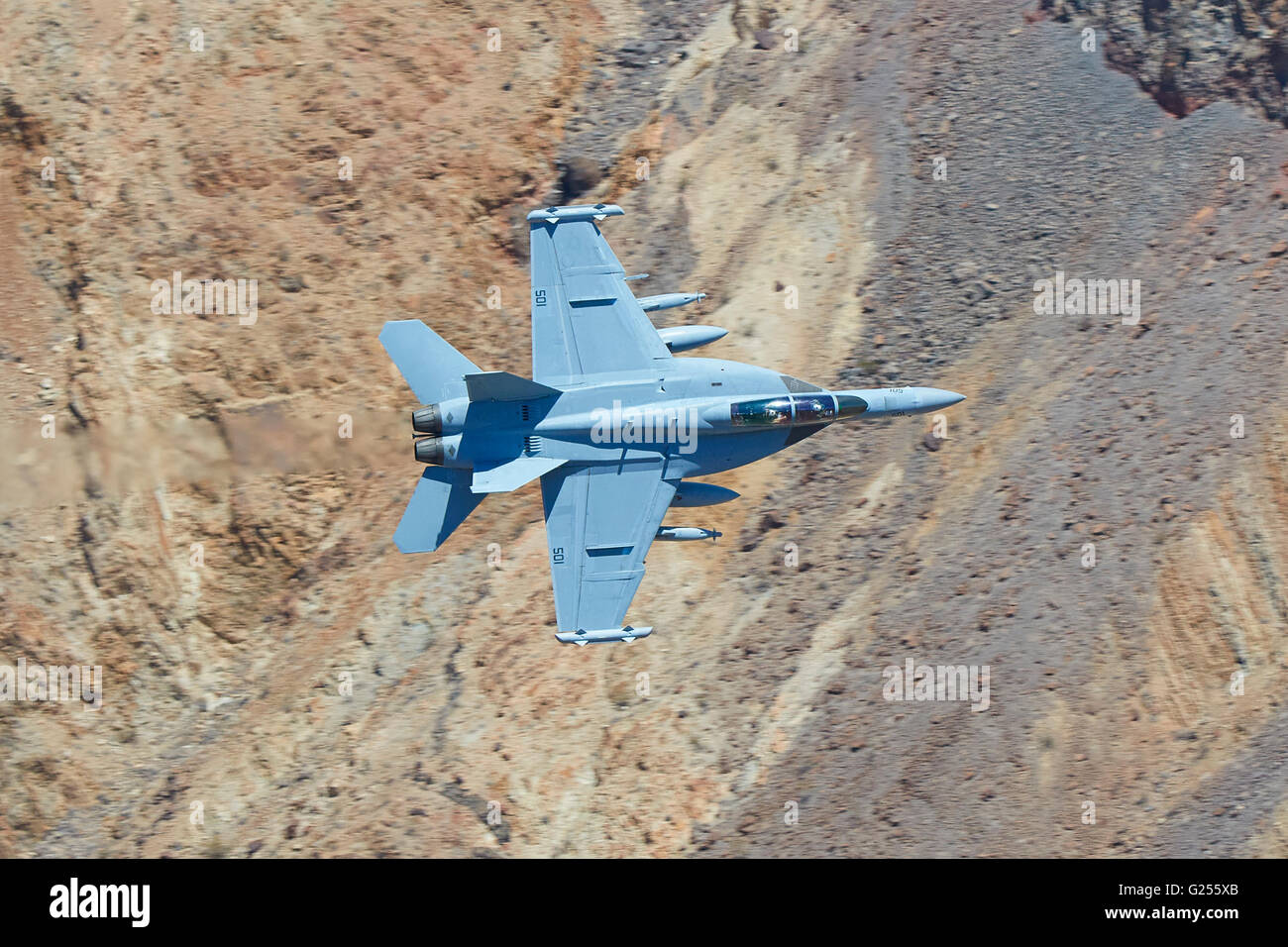 US Navy EA-18G Super Hornet, Growler, jet fighter banche bruscamente attraverso un canyon del deserto. Foto Stock