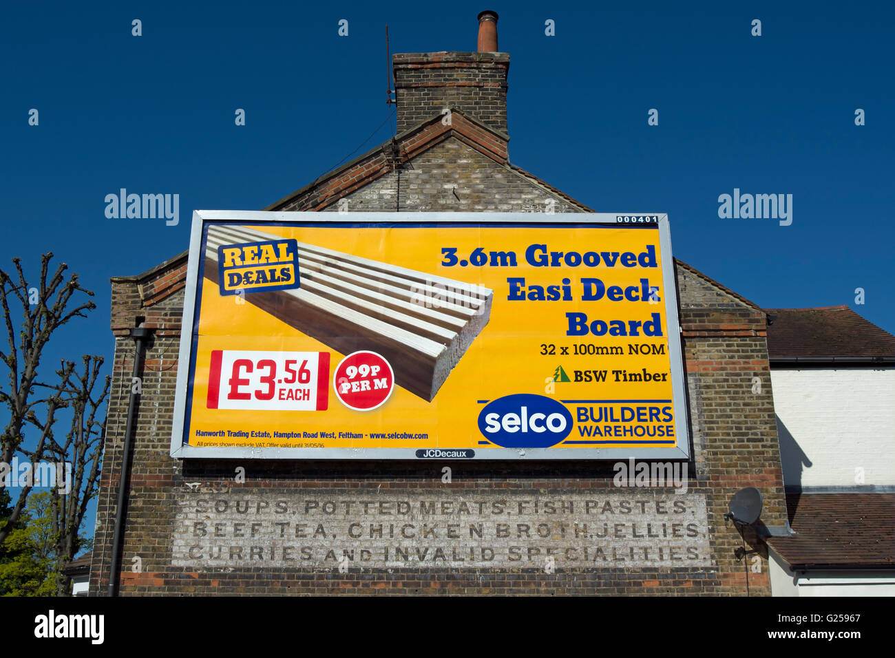 Contemporanea pubblicità tramite Affissioni scheda ponte al di sopra di un fantasma segno di una precedente attività, Twickenham, middlesex, Inghilterra Foto Stock