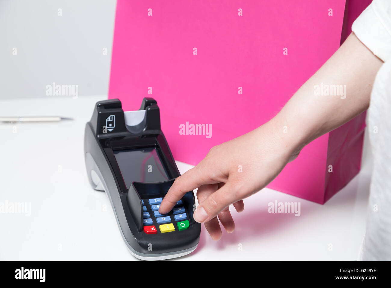 Donna inserendo il codice pin in un dispositivo di lettura per il pagamento in un negozio Foto Stock