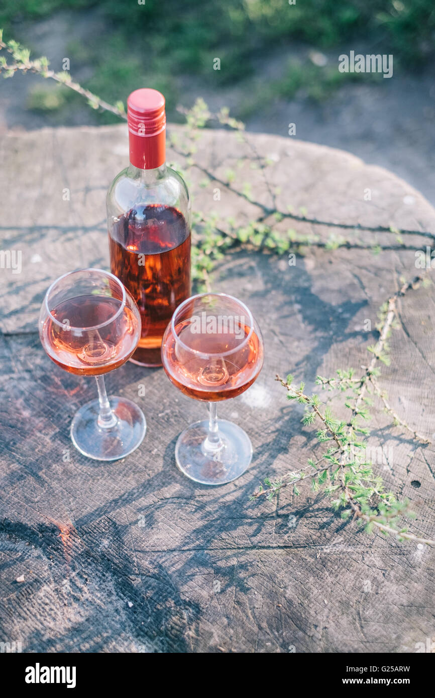 Bottiglia e due bicchieri di vino rosato Foto Stock