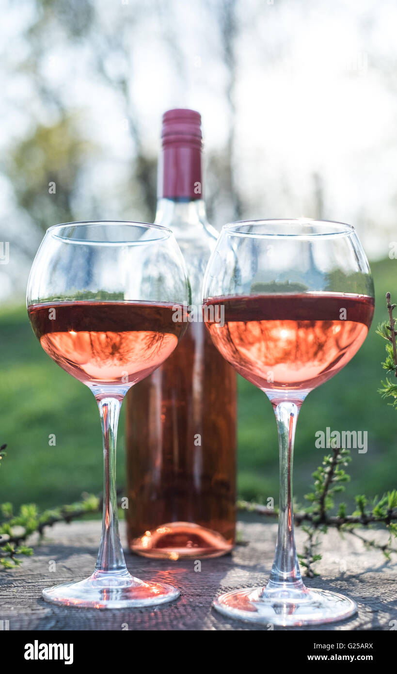 Bottiglia e due bicchieri di vino rosato Foto Stock