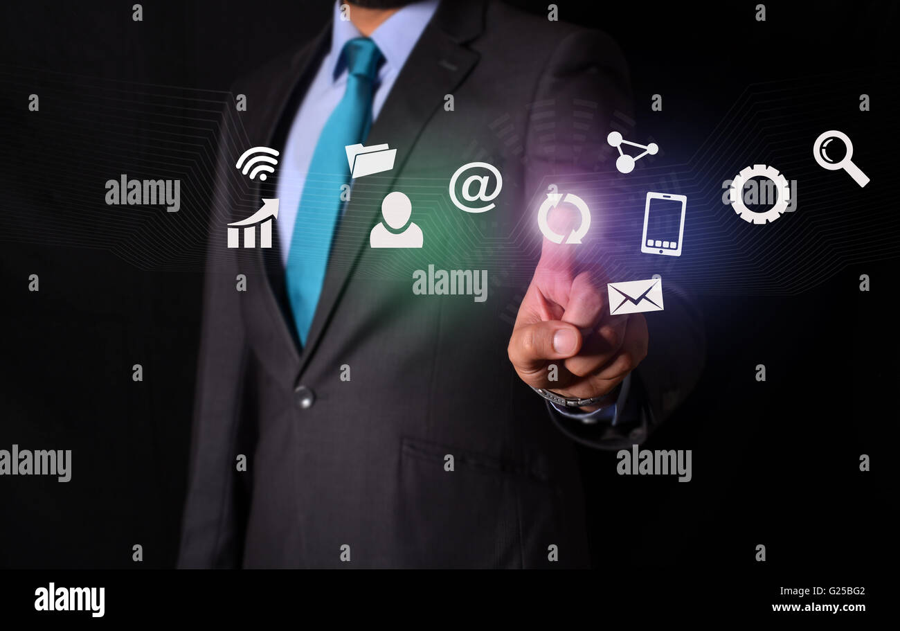 Imprenditore toccando le icone digitali schermo su sfondo nero. Foto Stock