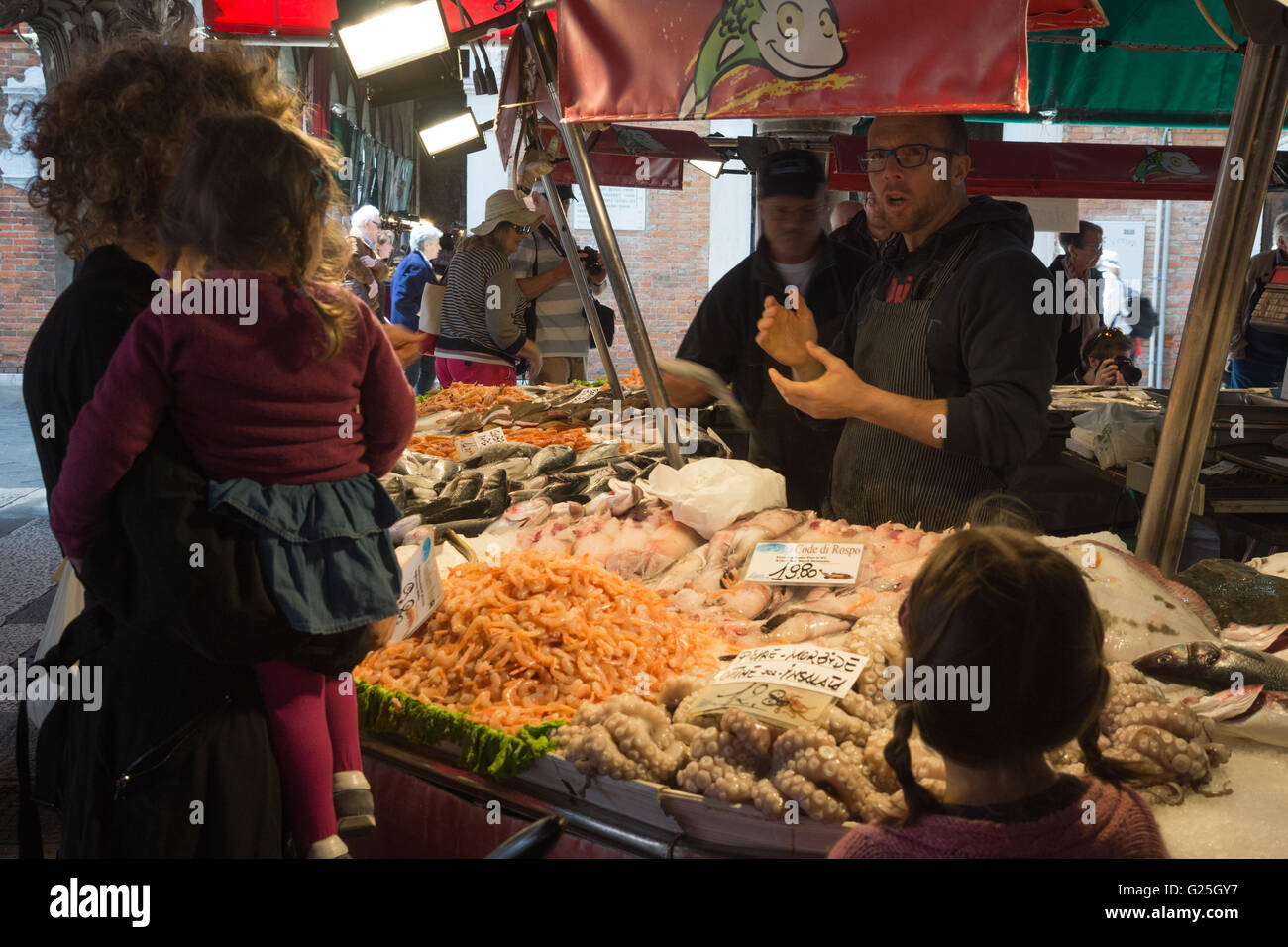 Una donna locale ordinare pesce in Pescaria, il Mercato di Rialto, Venezia Foto Stock