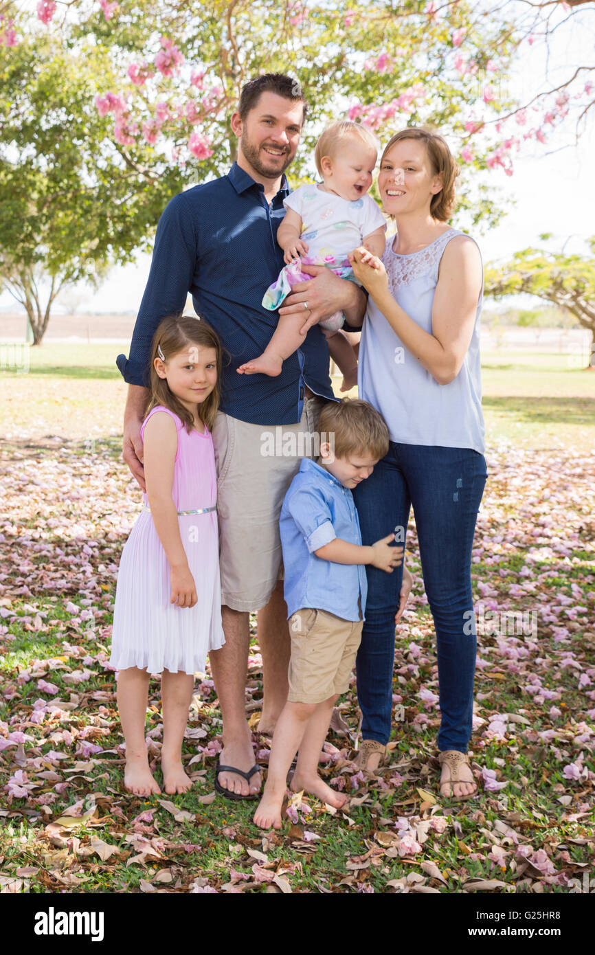 Padre e madre di tre figli nel parco in primavera Foto Stock