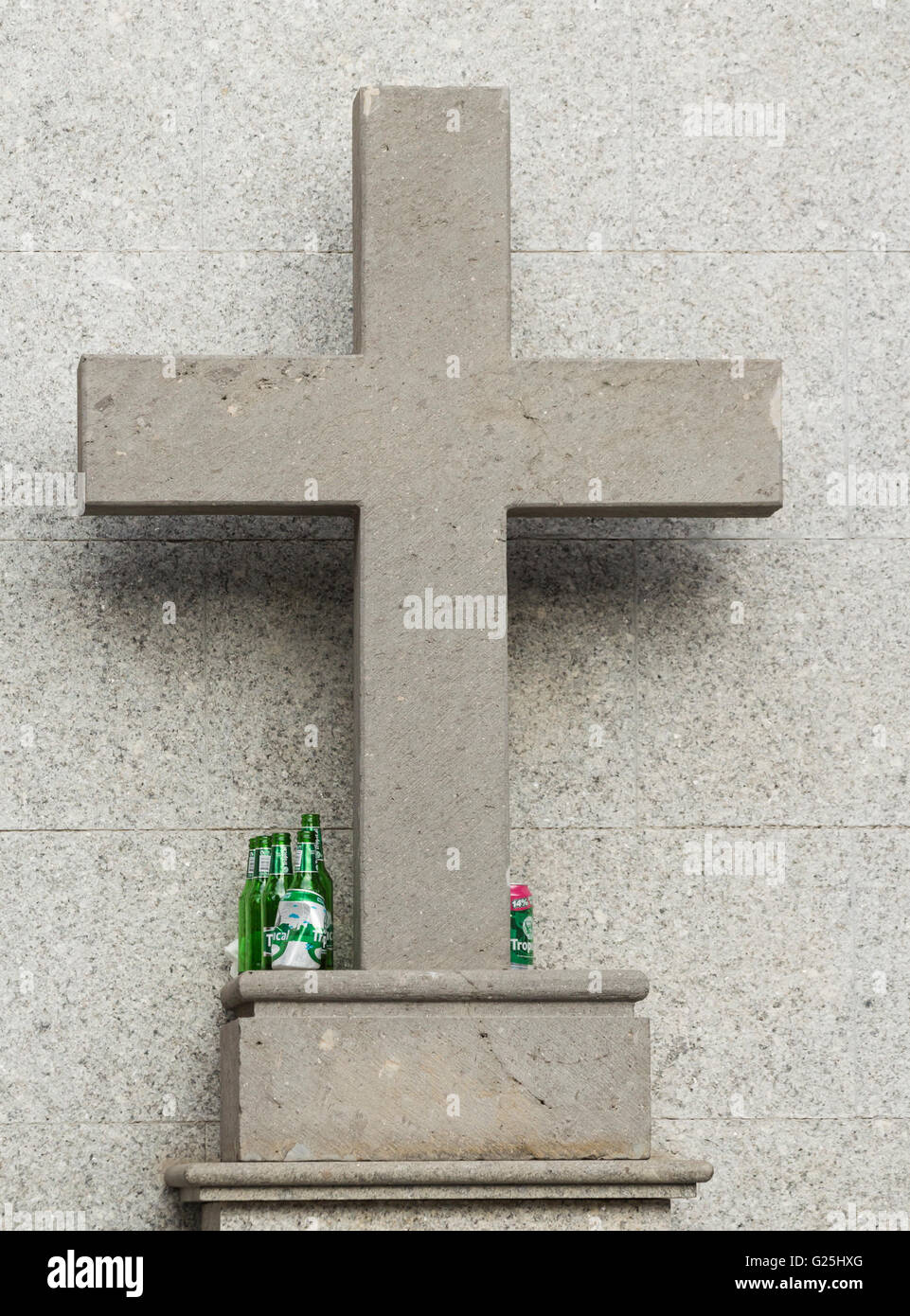 Svuotare le bottiglie di birra e lattine sulla croce sulla statua religiosa in Spagna Foto Stock