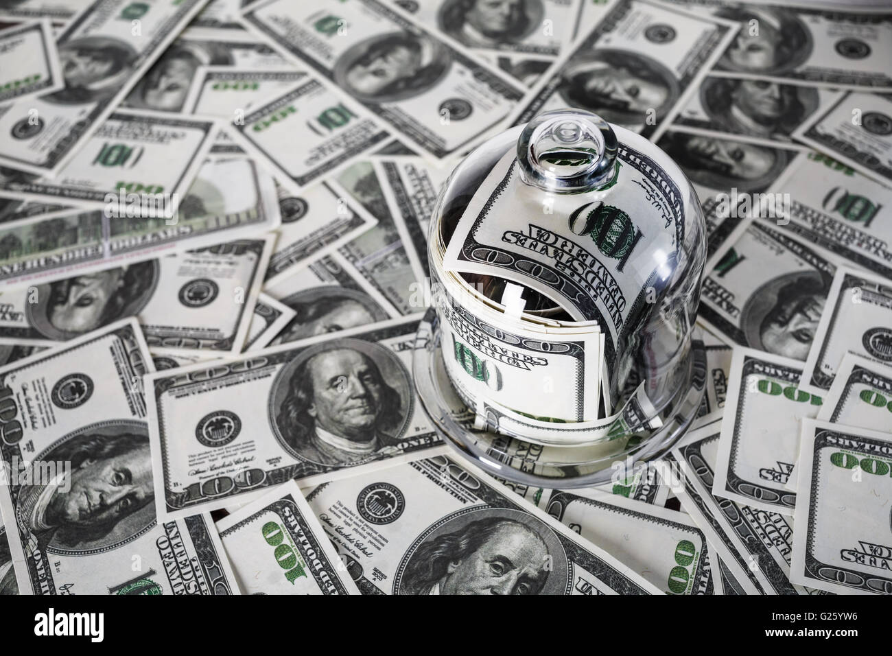 Il denaro in un vasetto di vetro sullo sfondo di un centinaio di fatture del dollaro. Foto Stock