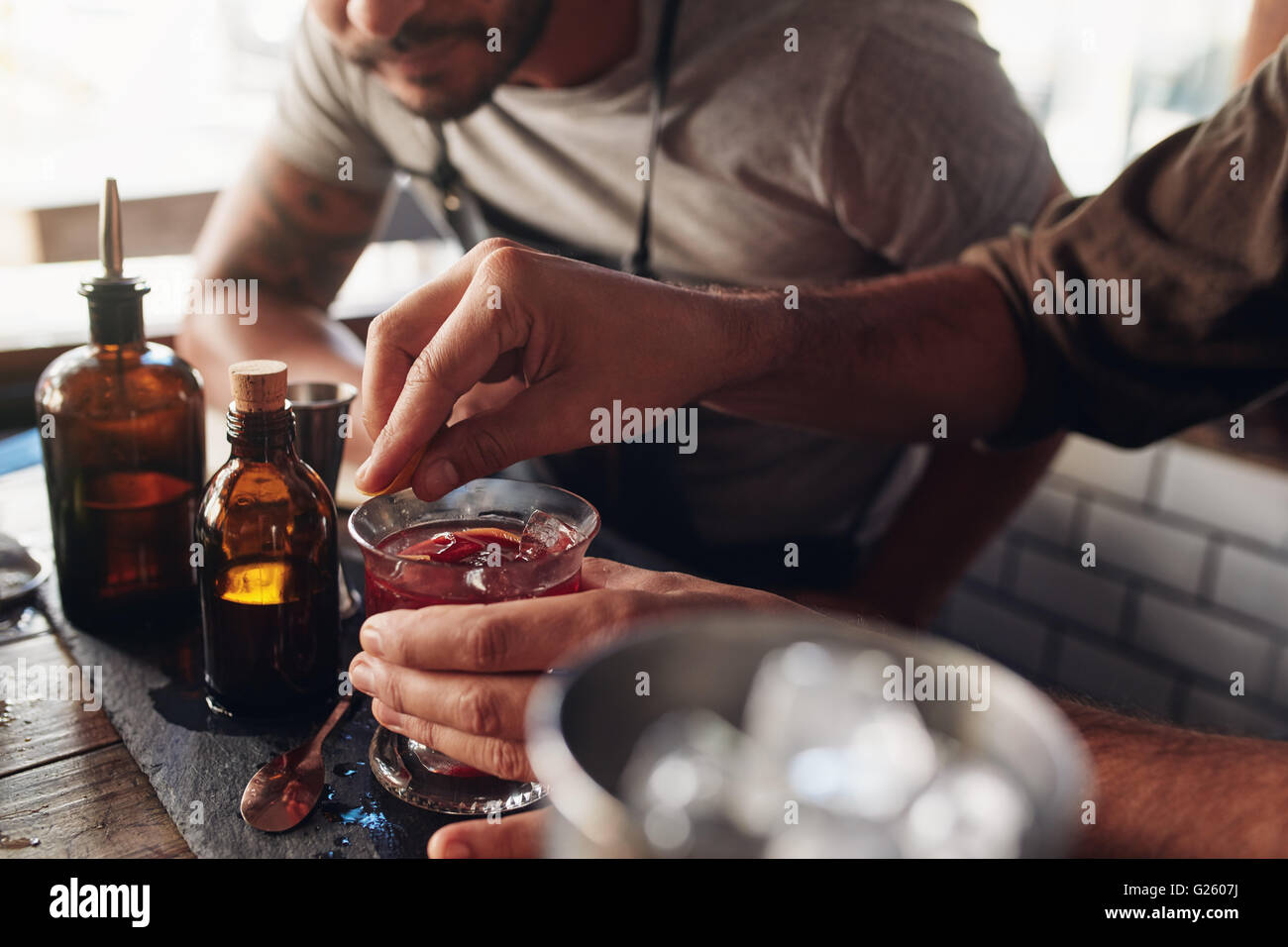 Due baristi a sperimentare con la creazione di cocktail di idee di miscelazione al bancone bar Foto Stock