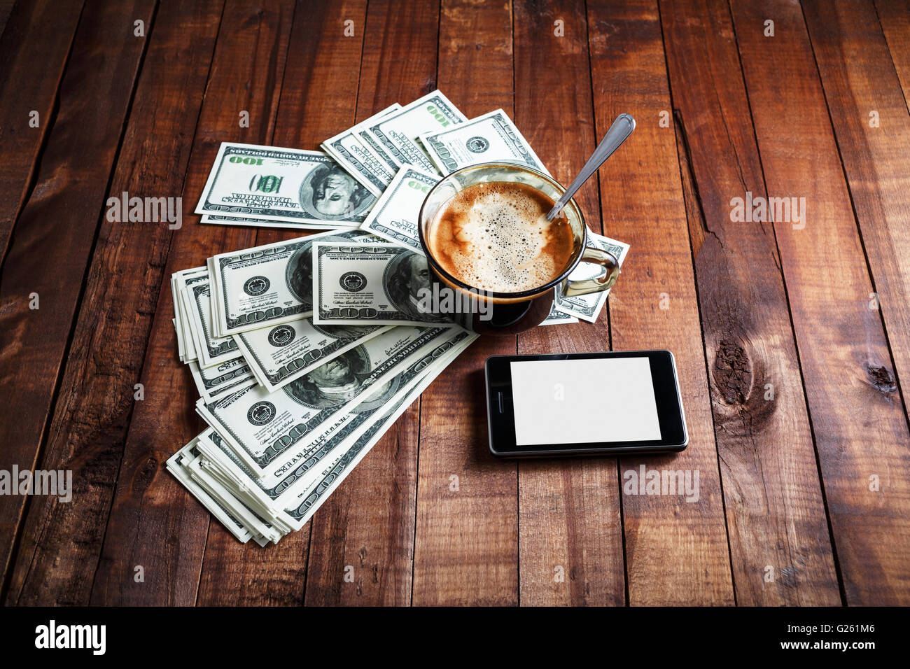 Tazza da caffè, denaro, dollari e telefono su vintage tavolo in legno sfondo. Foto Stock
