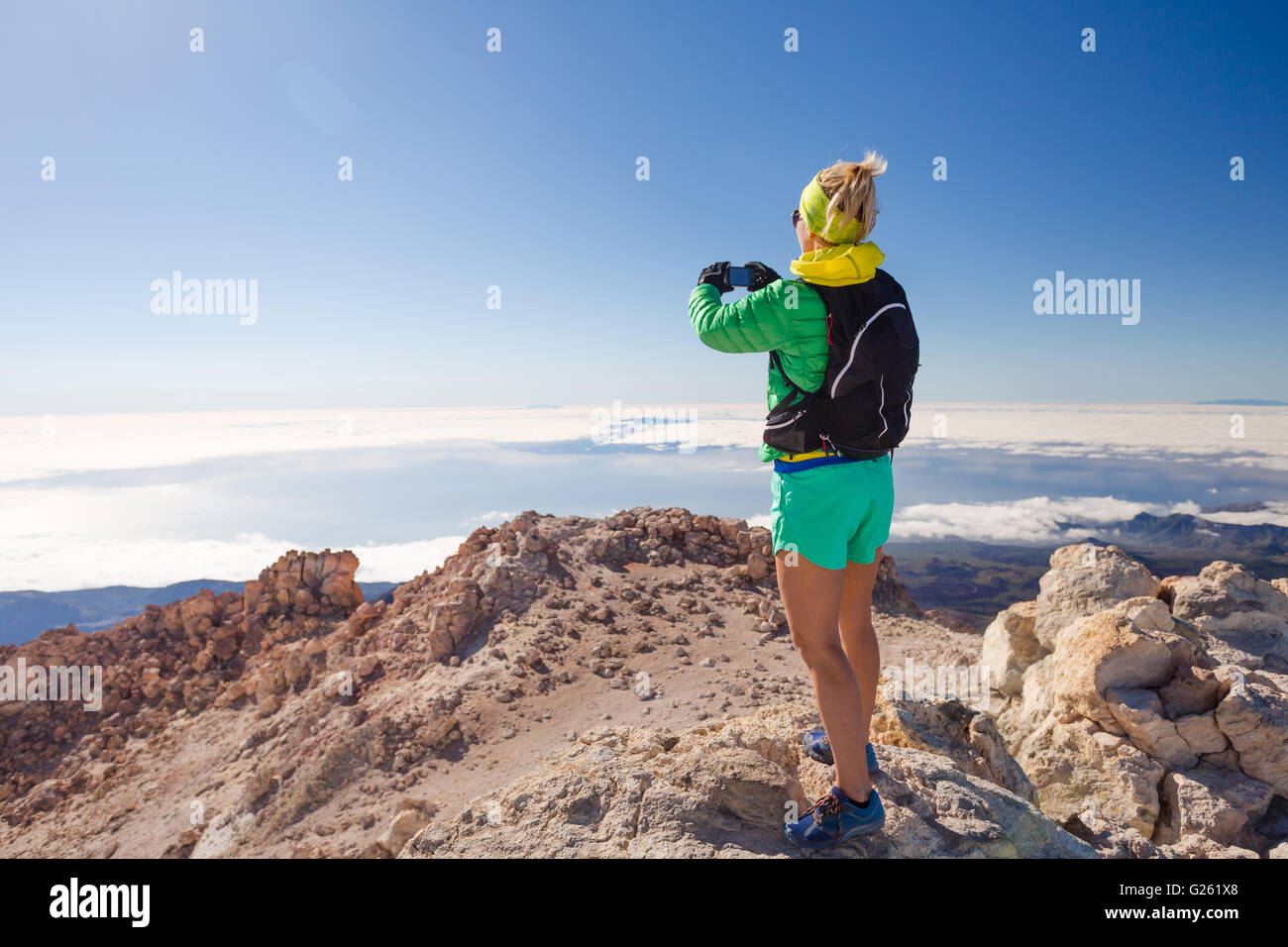 Escursionismo donna fotografare in montagna con smart phone. Utilizza lo smartphone all'esterno. Fitness e uno stile di vita sano all'aperto ho Foto Stock