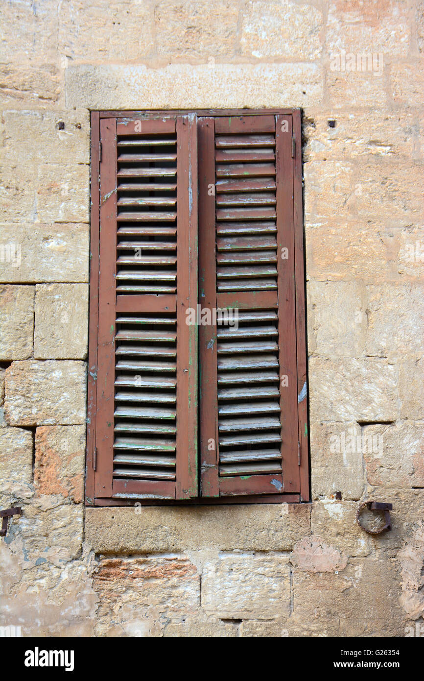 Finestra di antico in pietra e parete di mattoni Foto Stock