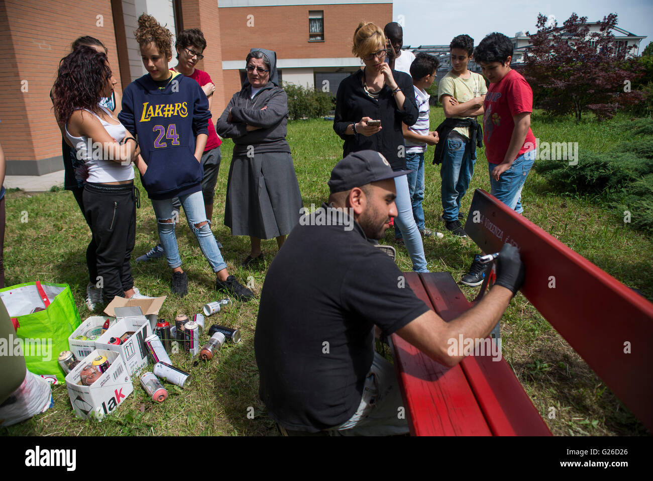 Torino, Italia. 25 Maggio, 2016. Lo scrittore da Torino Karim Chariff dipinte di rosso panca per dire no alla violenza contro le donne in corso Mortara, 36 a Torino Credito: Stefano Guidi/Alamy Live News Foto Stock