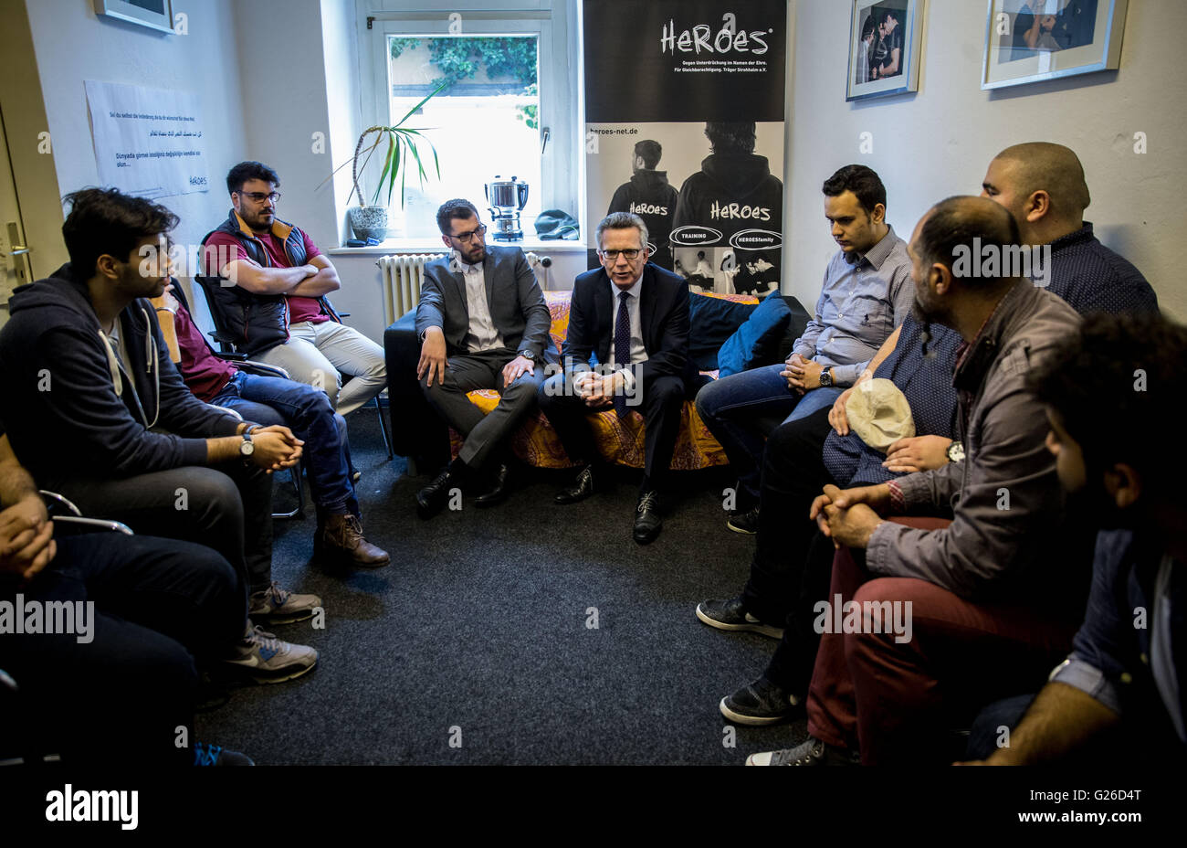 Berlin-Neukoelln, Germania. 25 Maggio, 2016. Il Ministro degli interni Thomas de Maiziere (CDU, M) Chat con giovani uomini dal progetto "Heroes" in Berlin-Neukoelln, Germania, 25 maggio 2016. Qui ci sono i giovani uomini, principalmente da immigrato sfondi, stanno guardando le percezioni delle loro culture e di mettere in discussione le nozioni di onore, sesso e ruoli sociali. Per questo gli uomini vengono messi in un anno di allenamento con 'hero'. Il "Heroes" quindi andare su tenendo seminari nelle scuole su di loro d'onore. Foto: KAY NIETFELD/dpa/Alamy Live News Foto Stock