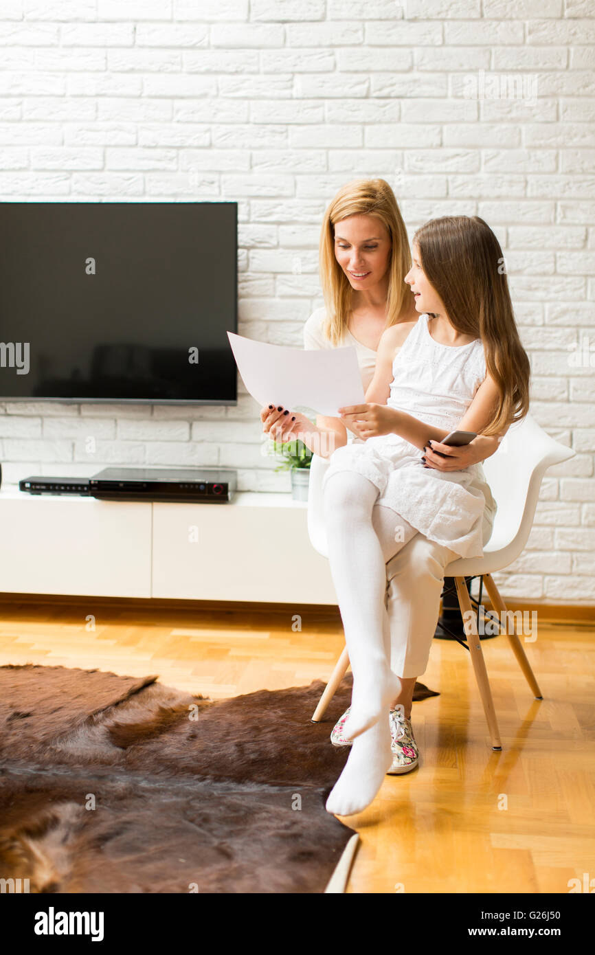 Ragazza che mostra un disegno per la madre a casa Foto Stock