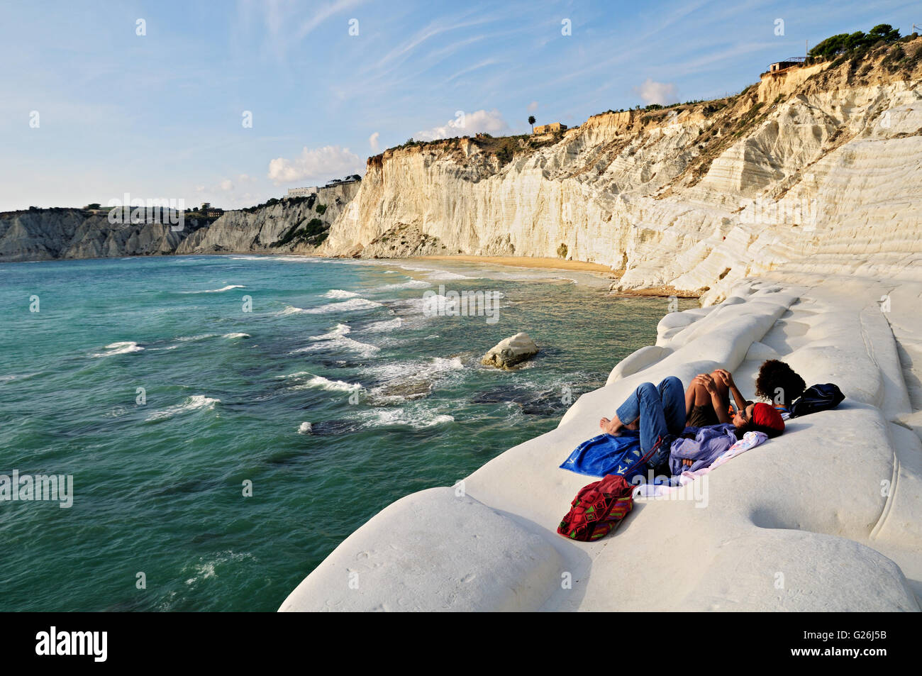 Due giovani donne rilassante sulla bella bianca scogliera di marna della Scala dei Turchi, Realmonte, Sicilia, Italia Foto Stock