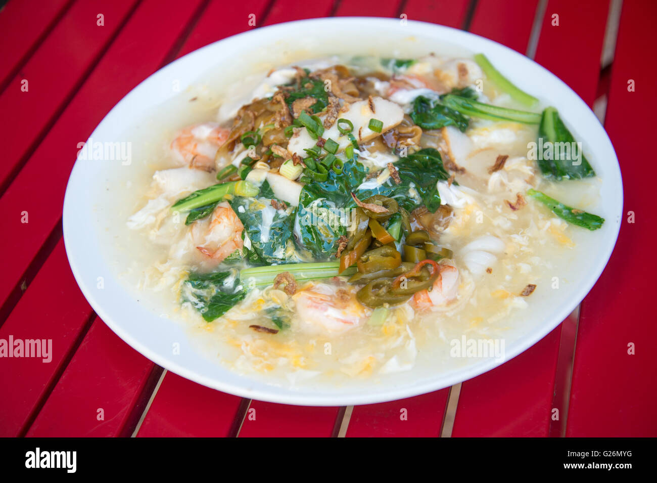 Piatto spaghetti di riso wok fritto con pesce, pollo e verdure serviti con sugo di uovo noto anche come Hor Fun Foto Stock