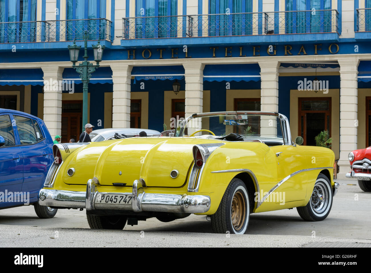 Un giallo vintage americano auto parcheggiate fuori Hotel Telegrafo, Parque Central, Havana, Cuba Foto Stock