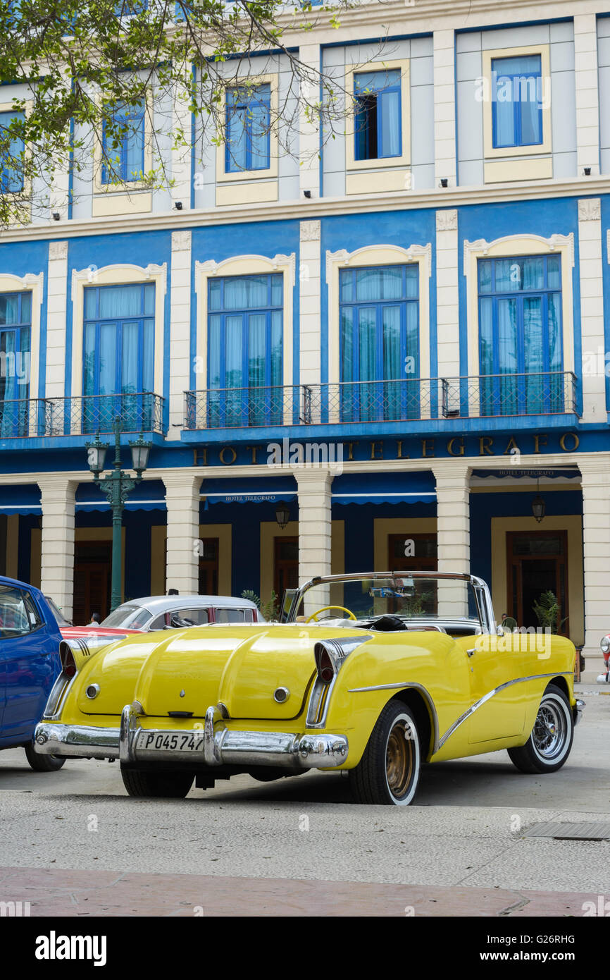 Di colore giallo brillante vintage americano auto al di fuori Hotel Telegrafo, Parque Central, l'Avana Vecchia Havana, Cuba Foto Stock