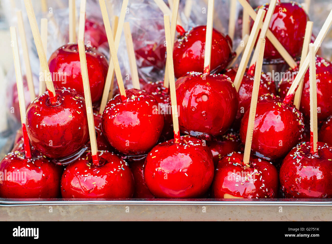 Dolce rosso smaltato toffee candy mele su bastoni per la vendita sul mercato contadino o country fair. Foto Stock