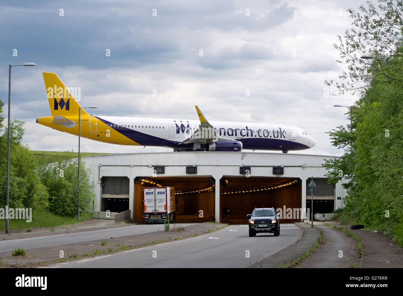 La Monarch compagnia aerea Jet rullaggio su A538 (Wilmslow Road) a Manchester Ringway Airport, Inghilterra Foto Stock