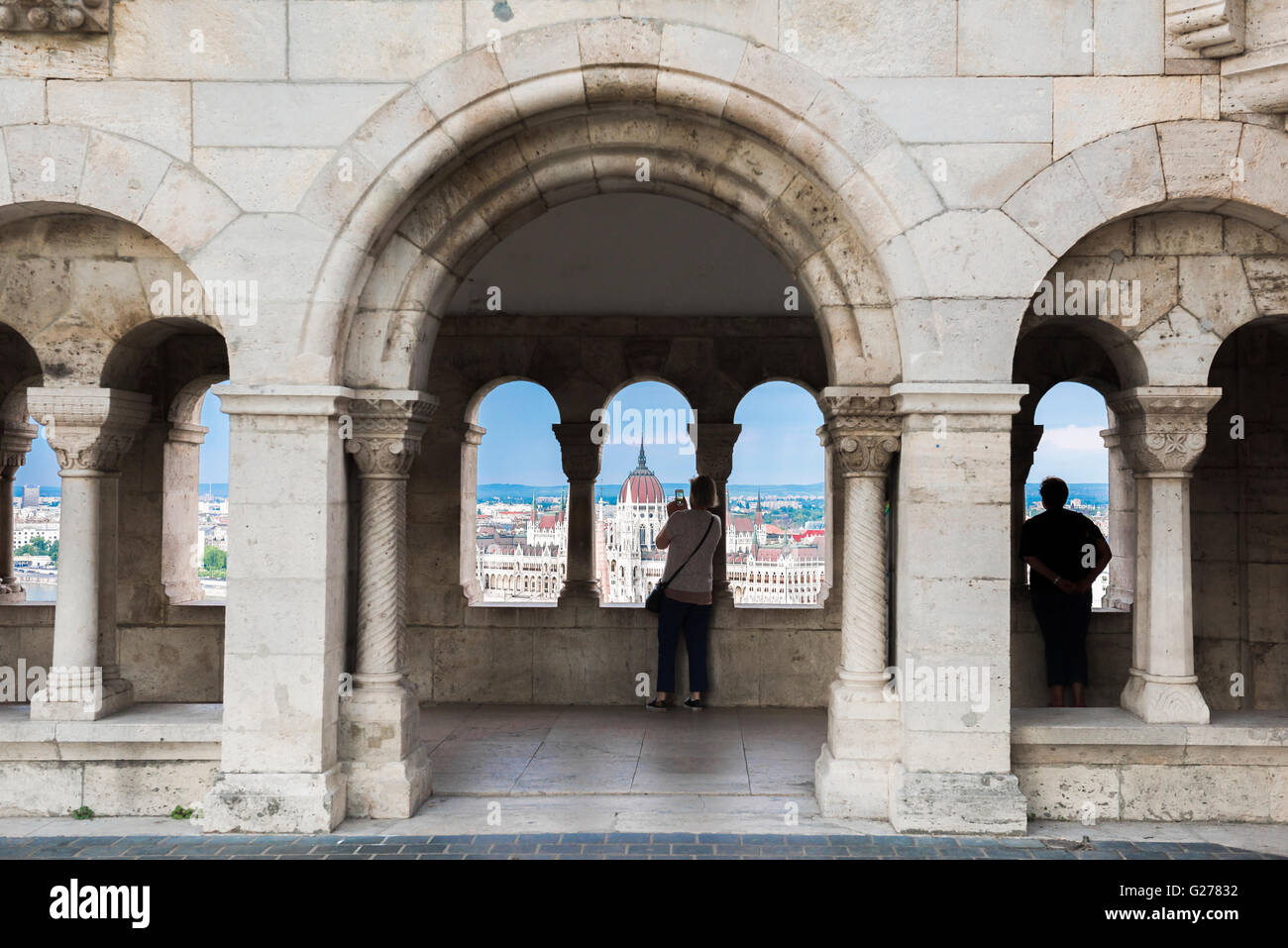 Turistico di Budapest, un turista in un chiostro interno il Bastione dei Pescatori nel Var area di Budapest scatta il punto di vista del Parlamento ungherese. Foto Stock