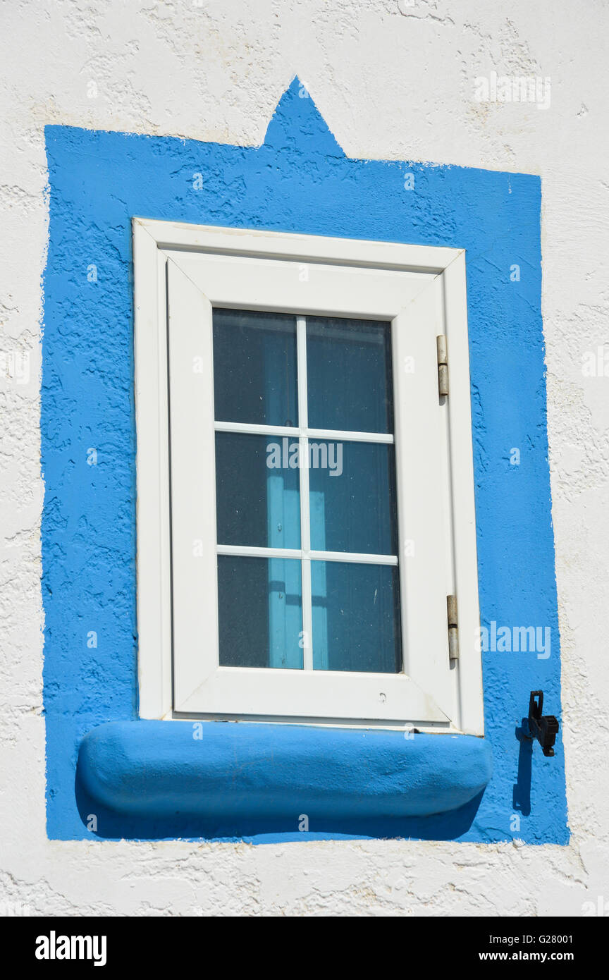 Blue con cornice in legno bianco chiuso la finestra vetrata su bianco lavato a parete, Grecia Foto Stock