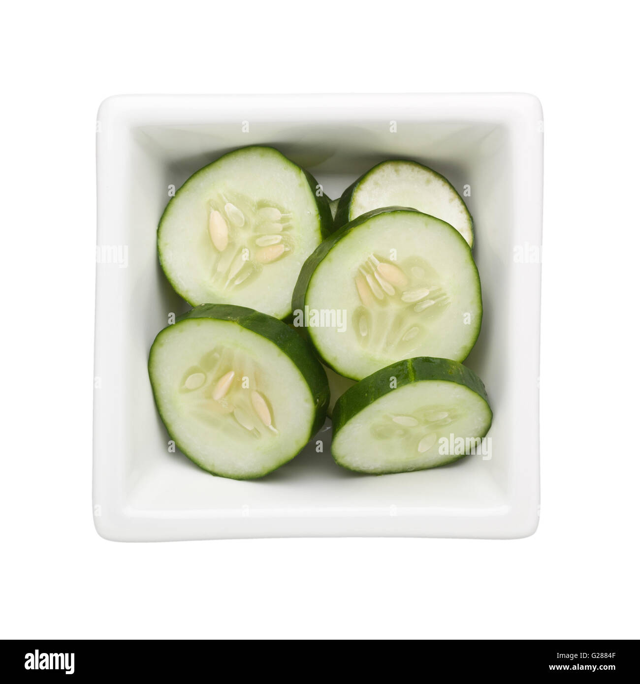 Cetriolo affettato in una vaschetta quadrata isolati su sfondo bianco Foto Stock