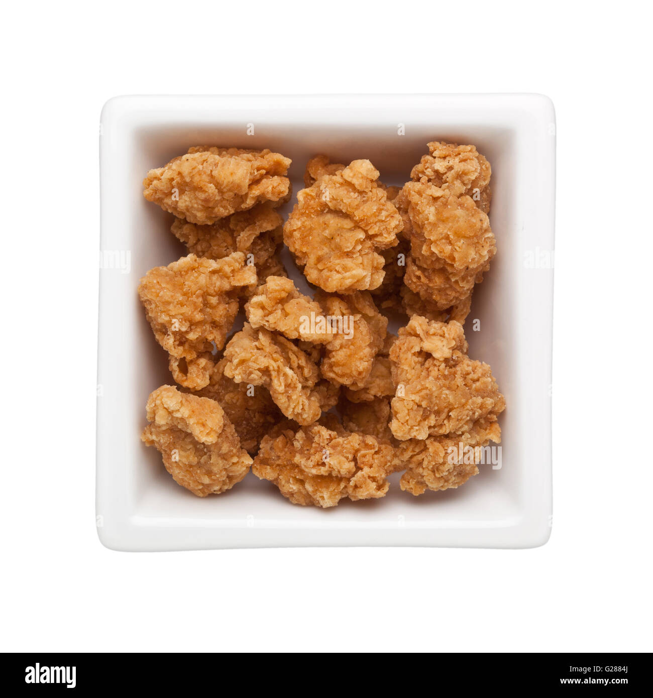 Fritte bite-size pollo in un recipiente quadrato isolato su sfondo bianco Foto Stock