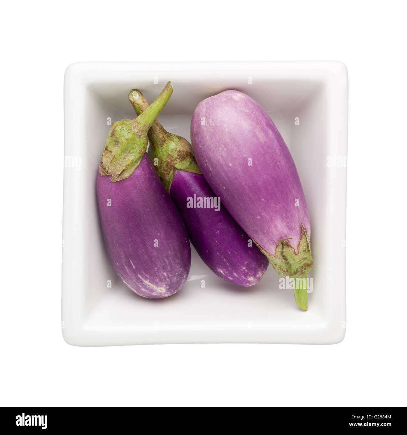 Mini melanzane in un recipiente quadrato isolato su sfondo bianco Foto Stock