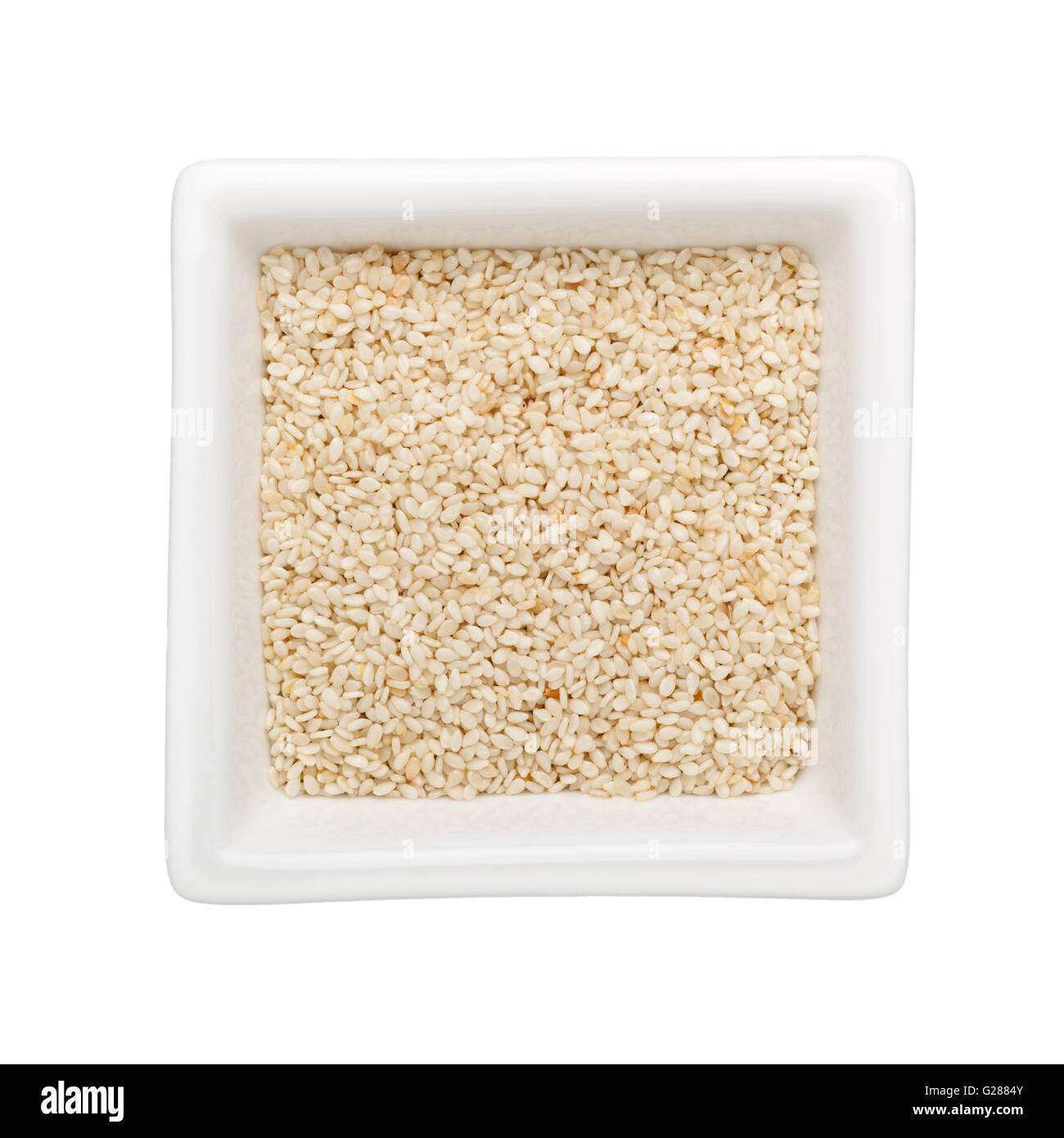 White Semi di sesamo in un recipiente quadrato isolato su sfondo bianco Foto Stock