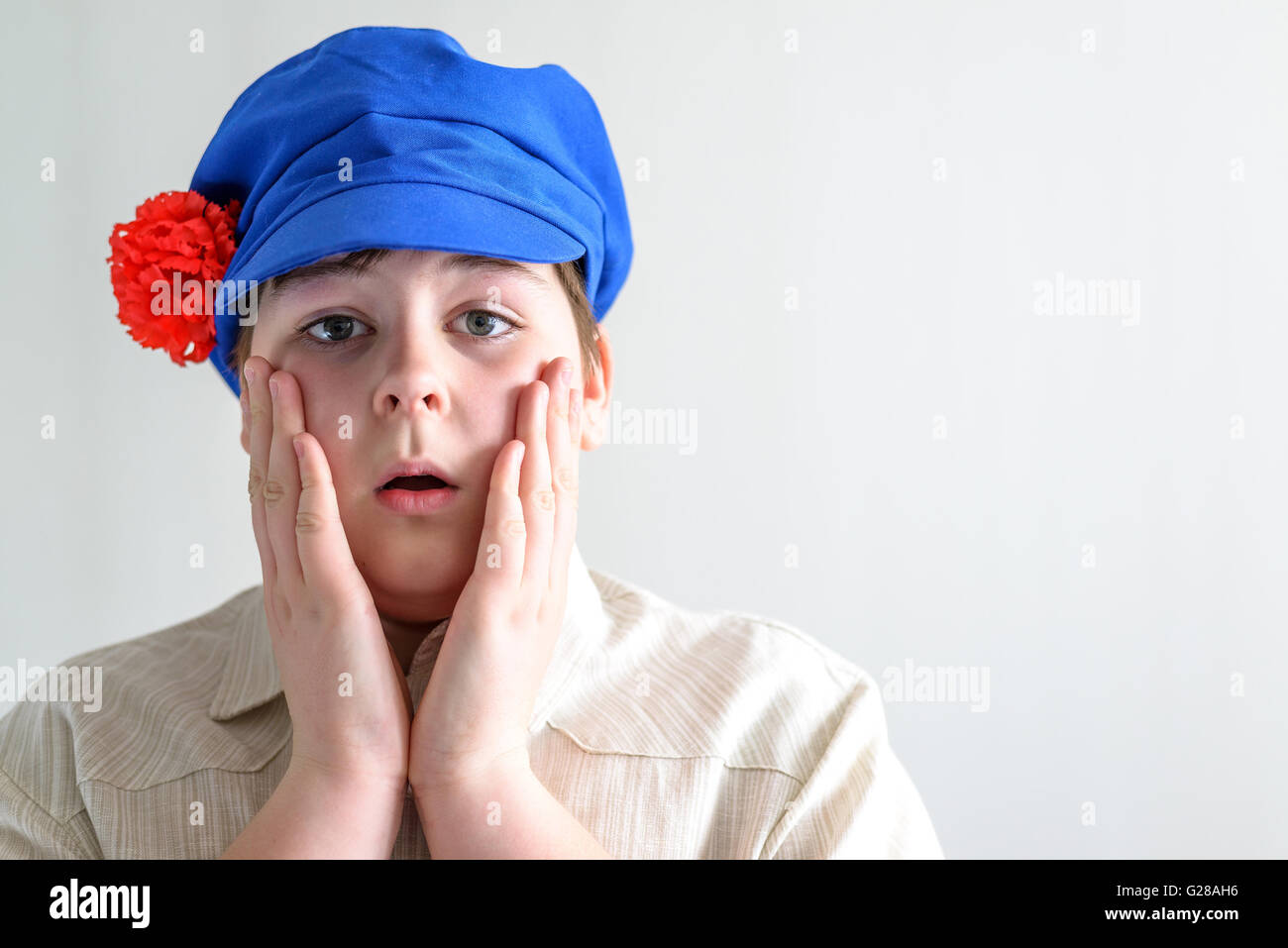 Ritratto di sorpresa ragazzo adolescente in russo cappuccio nazionale con chiodi di garofano Foto Stock