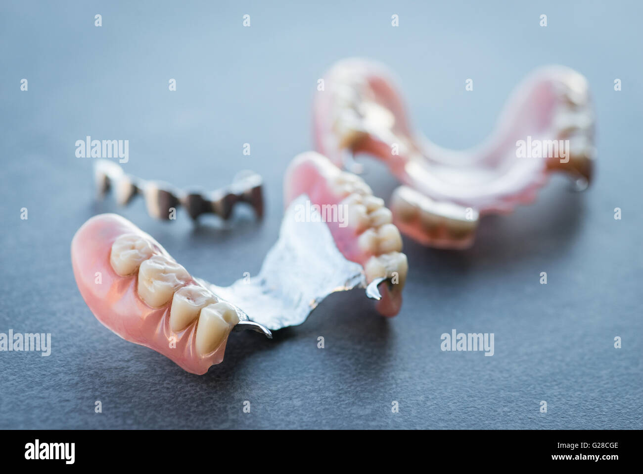 Sostituzione artificiale dei denti su di una superficie scura Foto Stock
