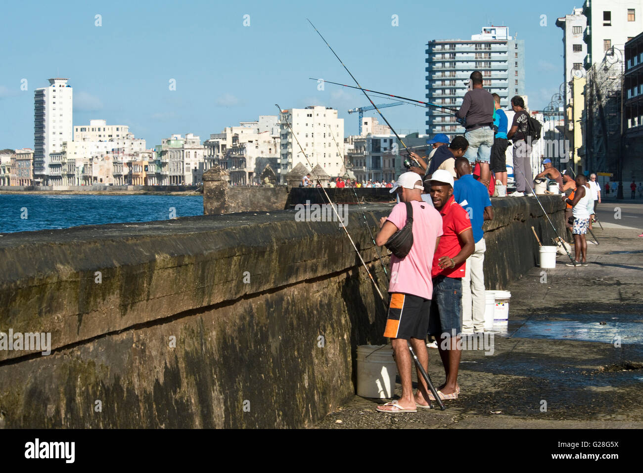 Pescatore locale pesca dal Malecón nella Città Vecchia di l'Avana. Foto Stock