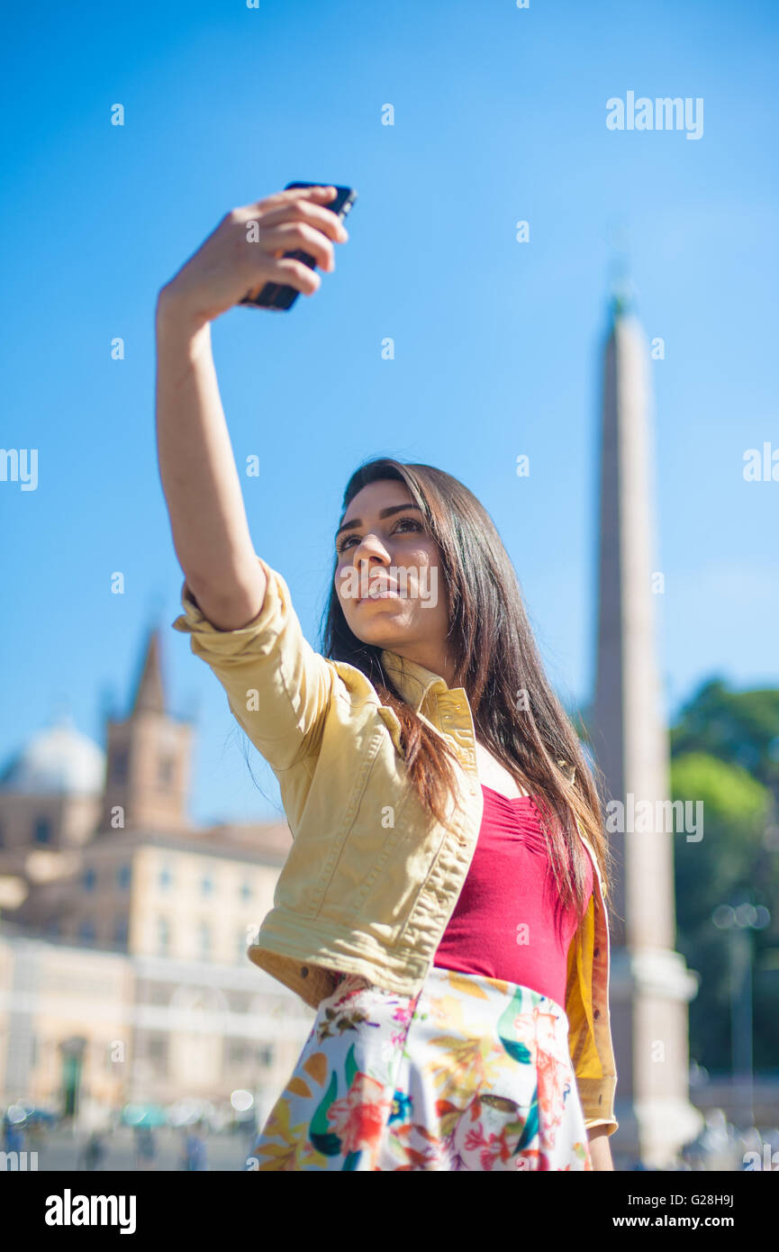Giovane donna turistica prendendo selfie foto con telefono mobile a Roma in piazza del popolo Foto Stock