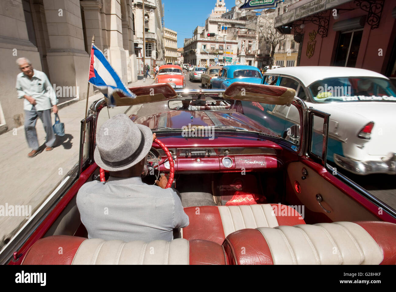 Un cubano taxi driver alla guida della sua Pontiac1955 Star Chief convertibile in città vecchia di l'Avana, Cuba. Foto Stock