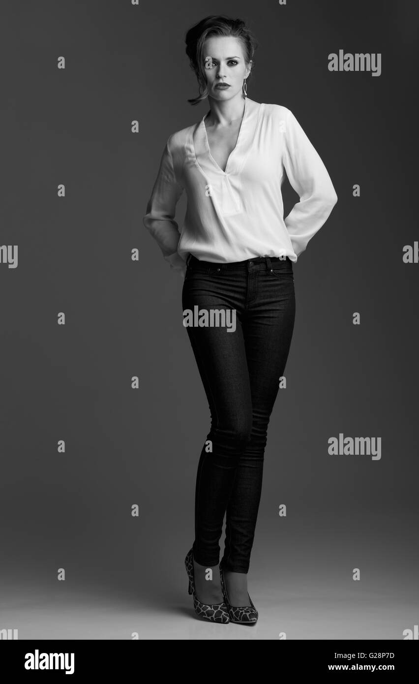 Donna contemporanea in bianco e nero per l'estetica. A piena lunghezza  ritratto della moderna donna elegante contro uno sfondo grigio Foto stock -  Alamy