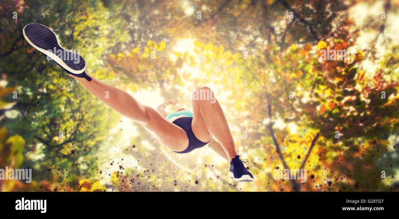 Immagine composita del basso angolo atleta femminile jumping Foto Stock