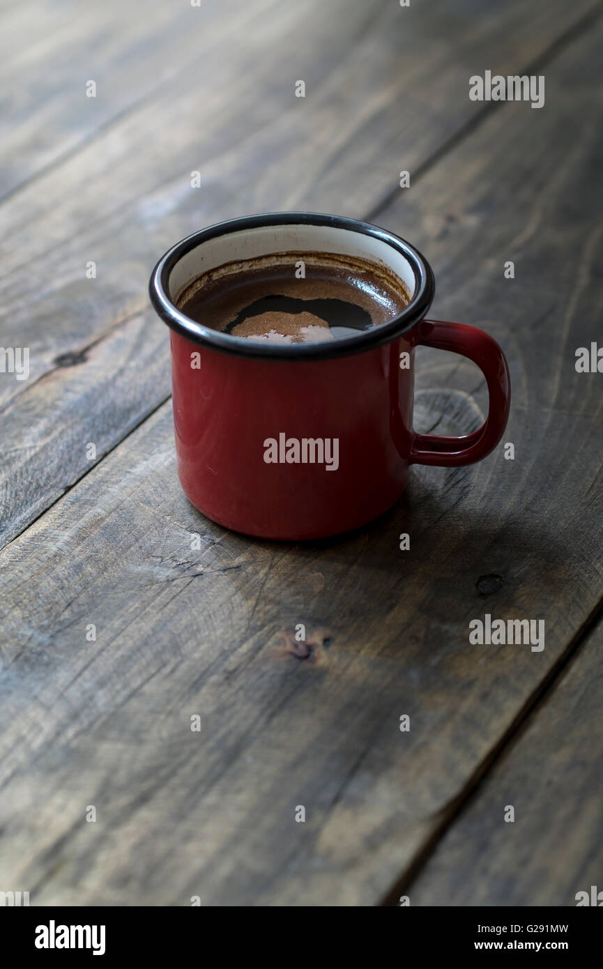 Tin la tazza con il caffè su sfondo di legno Foto Stock