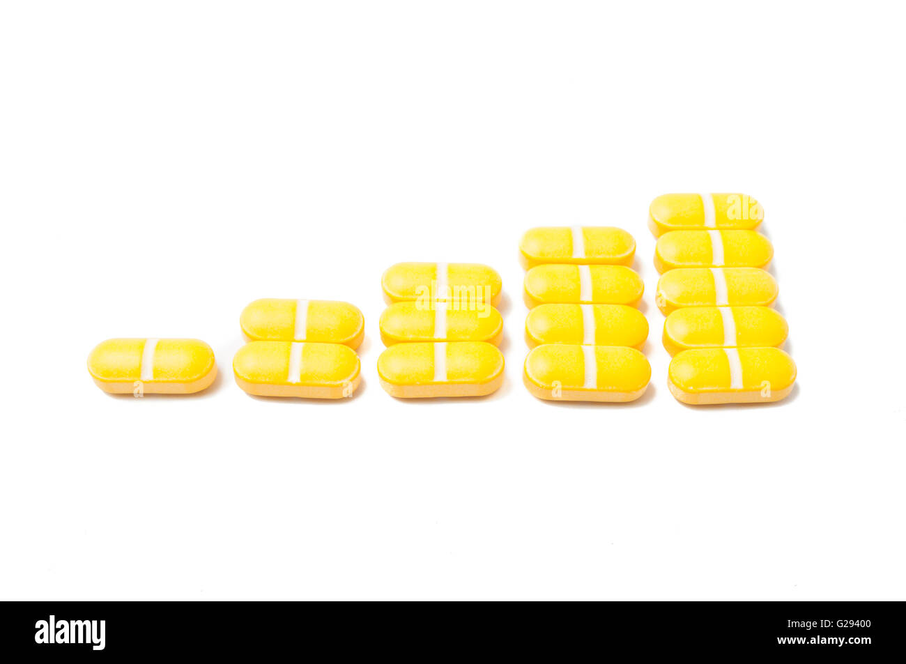 In crescita le vendite di medicina concetto grafico realizzato con giallo pillole impilati e isolato su sfondo bianco Foto Stock