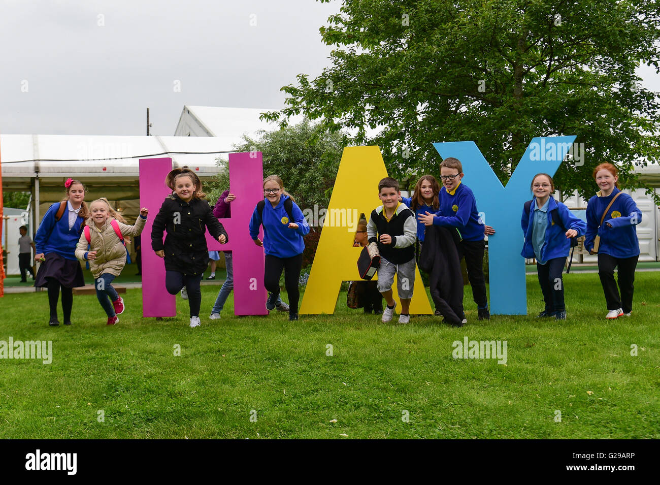 Hay on Wye, Wales, Regno Unito. 26 Maggio, 2016. Il giorno di apertura del Festival di fieno 2016, e gli studenti di scuole locali Divertiti con il grande segno di fieno sul sito del festival Photo credit: keith morris/Alamy Live News Foto Stock