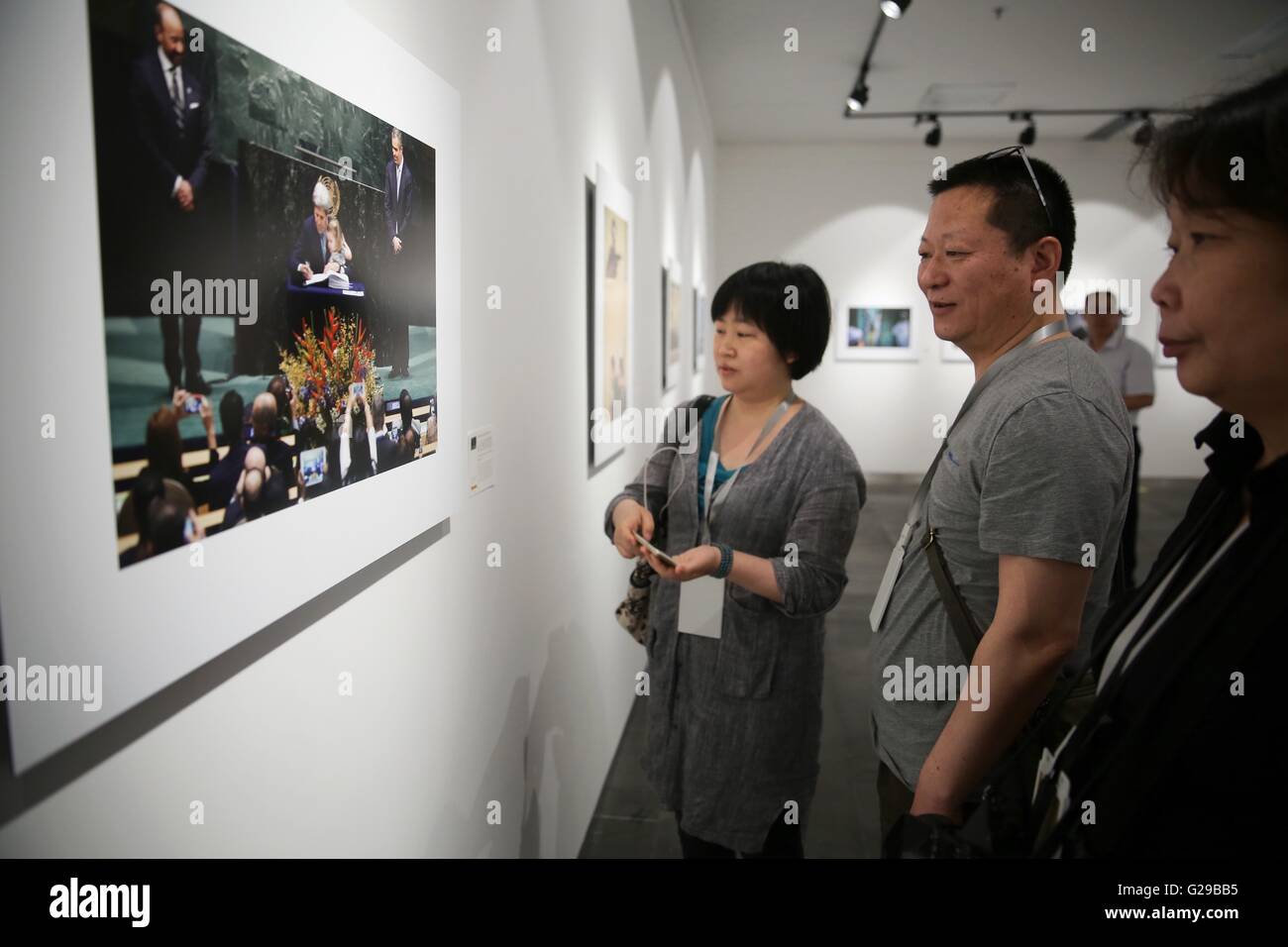 Zhengzhou, la Cina della Provincia di Henan. 26 Maggio, 2016. Visitatori guardare una news foto da Xinhua News Agency durante il China International Arte fotografica Festival (Società Cipaf) svoltasi a Zhengzhou, capitale della Cina centrale della Provincia di Henan, 26 maggio 2016. 738 Opere eccellenti selezionati da 110 mila opere provenienti da 88 paesi e regioni sono state visualizzate durante il festival dell'arte, che durerà per 8 giorni dal 26 maggio al 2 giugno. Credito: Cai Yang/Xinhua/Alamy Live News Foto Stock