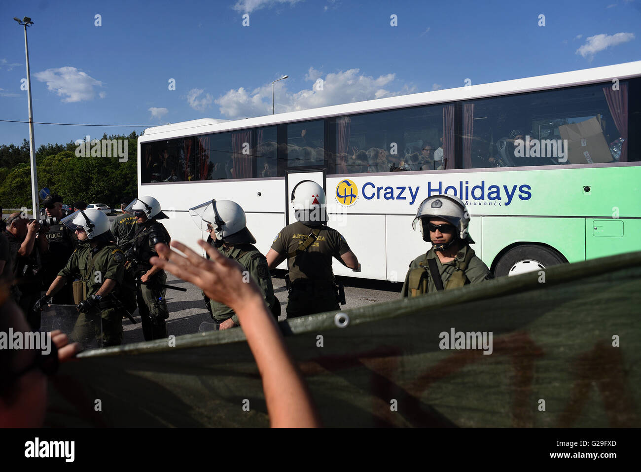 Idomeni, Grecia. Xxiv Maggio, 2016. Poliziotti antisommossa sostare davanti a un bus con i rifugiati di lasciare il border camp di Idomeni, vicino il greco-EX REPUBBLICA IUGOSLAVA DI MACEDONIA le frontiere, il 24 maggio 2016. Polizia greca evacuato il ripiego Refugee Camp in Idomeni e trasferito la maggior parte di essi alle nuove strutture di hosting in Sindos Derveni e vicino al nord della città greca di Salonicco. Solo 1.500 migranti sono stati lasciati in Idomeni. ©Elias Verdi/Alamy Live News Foto Stock