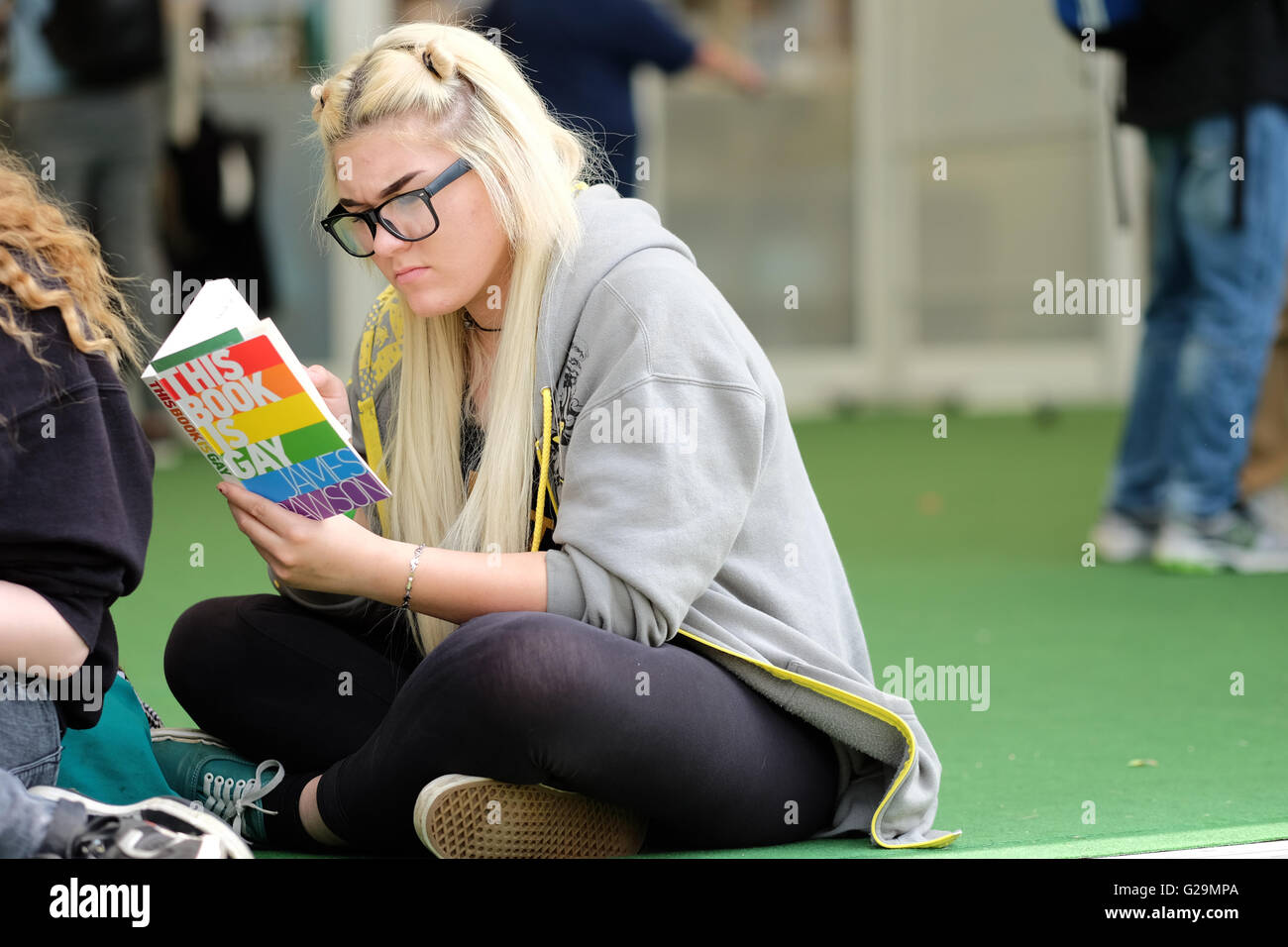 Hay on Wye, Wales, Regno Unito. 27 Maggio, 2016. Un festival giovane visitatore gode la possibilità di sedersi e leggere il suo nuovo libro come il sole splende il giorno 2 del fieno Festival. Fotografia Steven Maggio / Alamy Live News Foto Stock