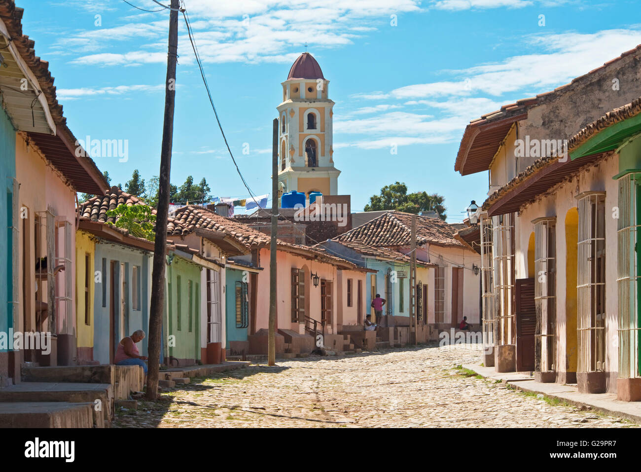 Tipica strada vicino al centro di Trinidad di Cuba e il Convento de San Francisco de Asís torre campanaria nel retro di massa. Foto Stock