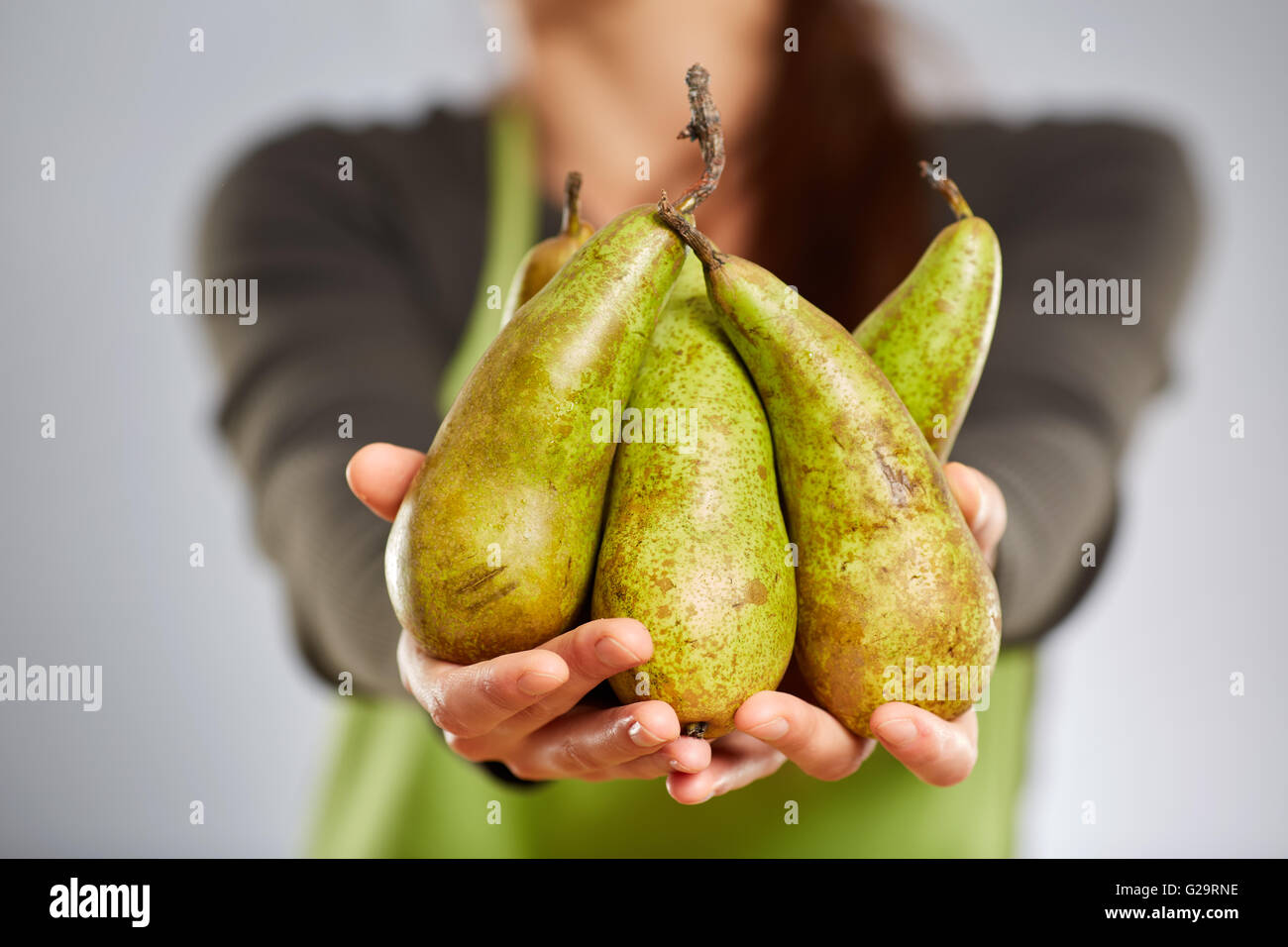 Le mani di una donna cuocere tenendo un mazzetto di pere Foto Stock