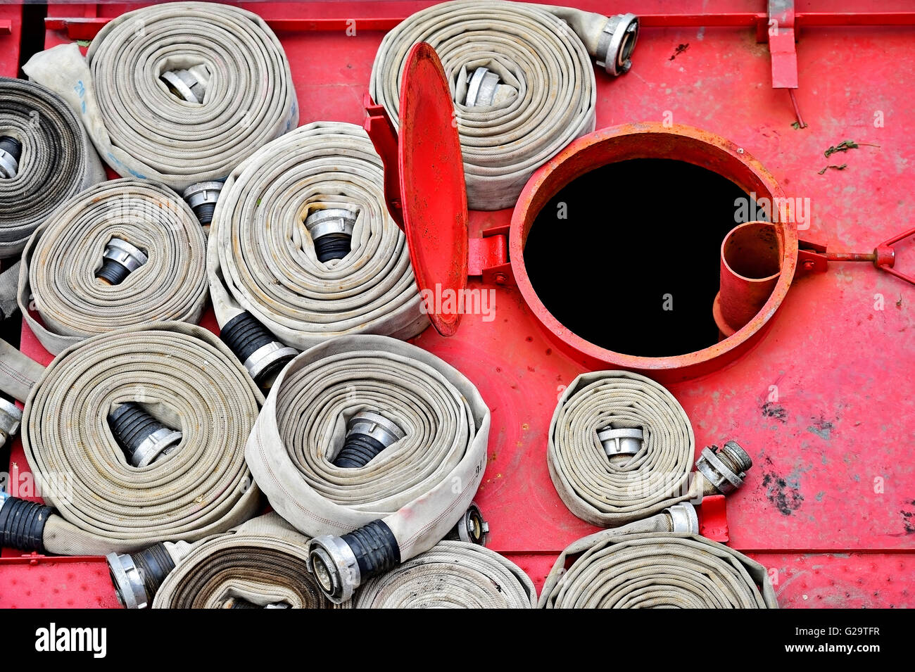 Dettaglio con pesanti tubi flessibili di acqua sulla parte superiore di un vigile del fuoco veicolo Foto Stock