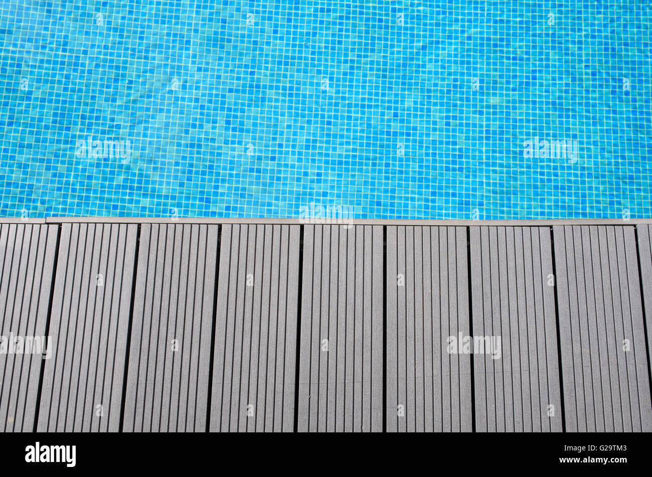 Decking in corrispondenza del bordo di blu a mosaico piscina Foto Stock
