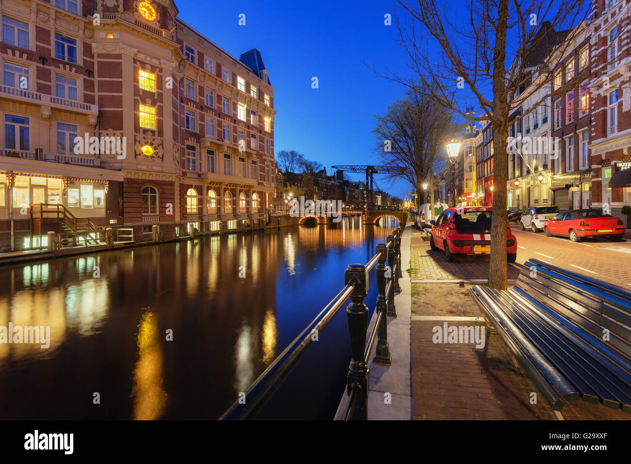 Beautiful Night cityscape con tradizionale vecchie case di Amsterdam, Paesi Bassi. Riflette le luci della città in acqua con il blu del cielo. Foto Stock